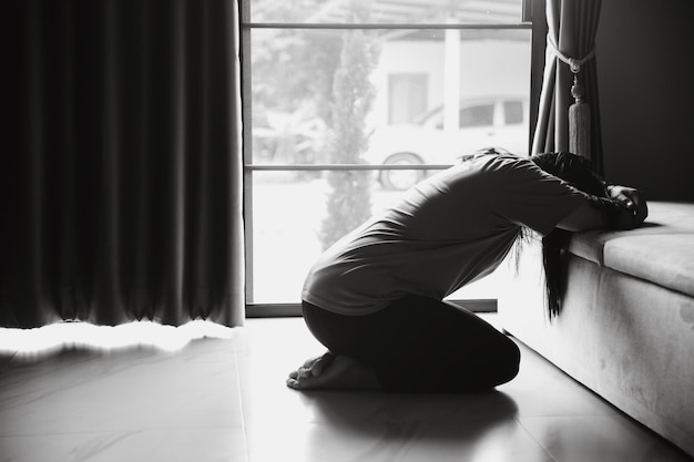 Schizophrenie mit einsamem und traurigem Depressionskonzept für psychische Gesundheit Depressive Frau, die zu Hause auf dem Boden sitzt und sich in einem dunklen Raum elend fühlt Frauen sind depressiv, ängstlich und unglücklich