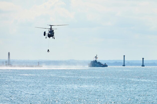 Schlachtschiff-Kriegsschiff-Korvette während Marineübungen und Hubschraubermanöver über Wasser in der Ostsee. Kriegsschiffe, Hubschrauber und Boote führen Aufgaben im Meer aus, militärische Kriegsschiffe segeln, russische Marine