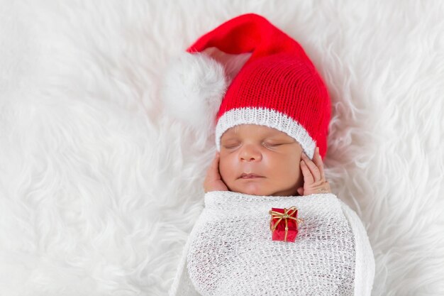 Schläfer neugeborenes Baby in einer Weihnachts-Sankt-Mütze