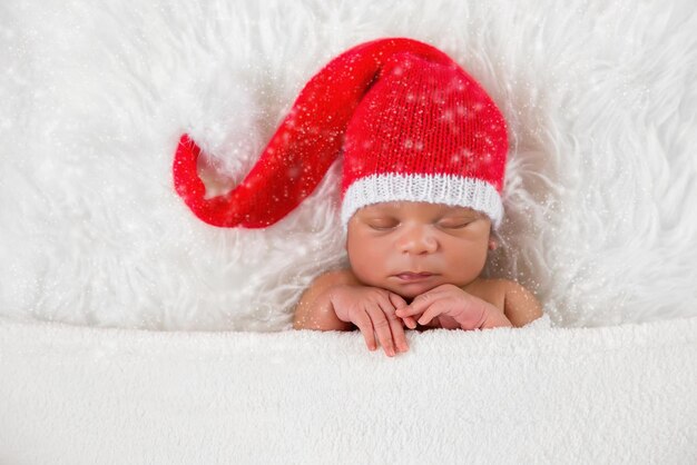 Schläfer neugeborenes Baby in einer Weihnachts-Sankt-Mütze