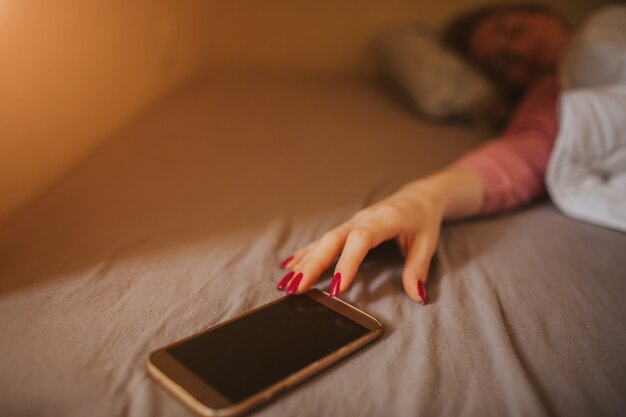 Schläfrige junge Frau, die mit Alarm aufwacht. Sie verschlief zur Arbeit