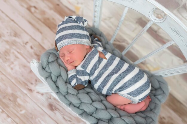 Foto schlafendes neugeborenes baby im korb, eingewickelt in eine decke im weißen fellhintergrund porträt des kleinen kindes
