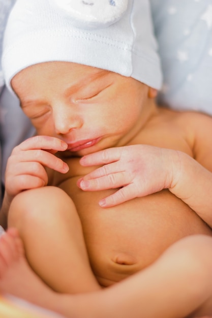 Schlafendes neugeborenes Baby mit einem lustigen Hut. Babyface-Nahaufnahme. Sehr süßes Baby.
