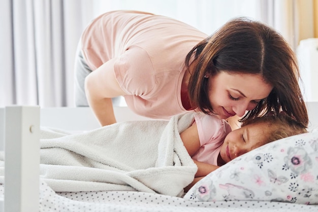 Schlafzeit Junge Mutter mit ihrer kleinen Tochter in Freizeitkleidung zusammen zu Hause