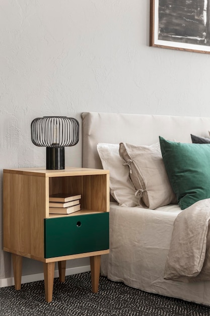 Schlafzimmerdesign in Beige und Smaragd mit moderner Lampe auf Nachttisch aus Holz
