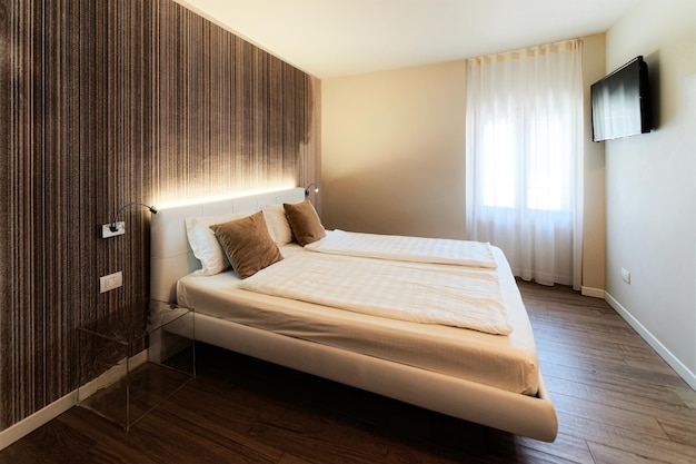 Schlafzimmereinrichtung und moderne Designmöbel und Wandmalerei. Zimmer in Wohnung mit Bett und weißen Kissen und Decke und Kunsthausdekor. Italienischer Stil im Hotelbereich