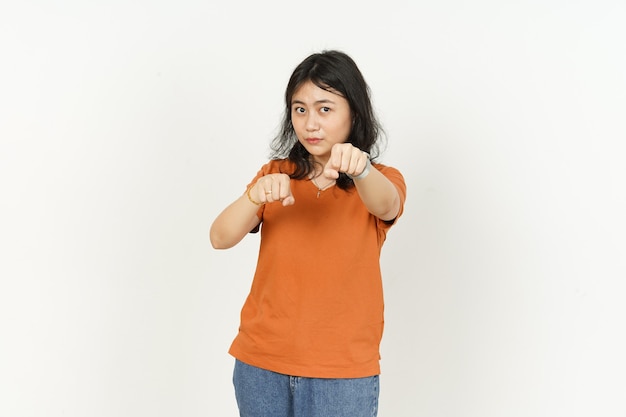 Schlagfaustgeste einer schönen asiatischen Frau mit orangefarbenem T-Shirt isoliert auf weiß machen