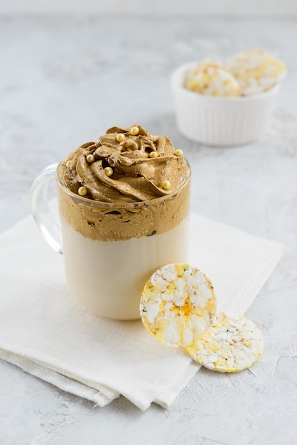 Schlagsahne Kaffee in einer Glasschale mit Snacks auf einer weißen Serviette geschlagen.