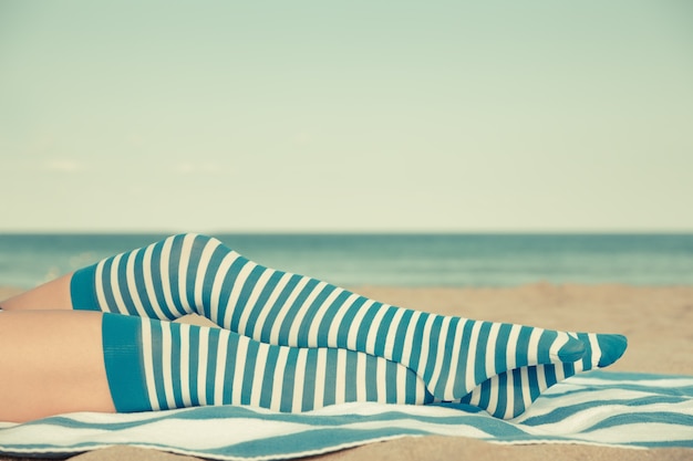 Schlanke Frauenbeine am Strand. Sommerurlaub und Reisekonzept. Retro