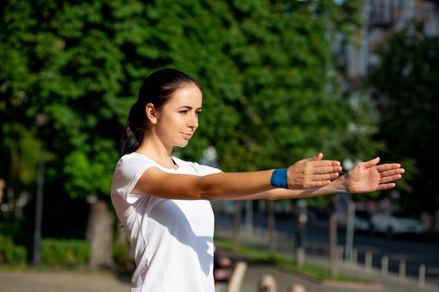 Schlankes sportliches Mädchen, das morgens ihr Handtraining mit blauem Gummiband macht