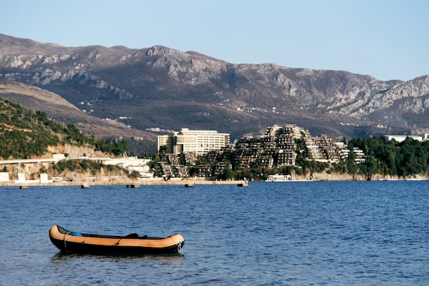 Schlauchboot auf dem Meer vor dem Hintergrund der Küste mit Häusern grüne Bäume und Berge