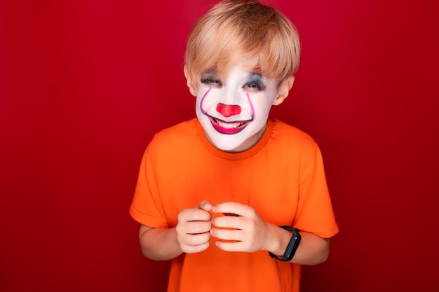 Schlauer Junge mit Make-up für den Halloween-Feiertag lächelt, kneift die Augen zusammen.