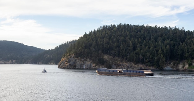 Schlepper in kanadischer Landschaft am Meer und in den Bergen