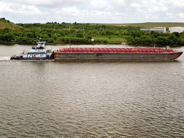 Schlepper zieht Lastkahn in den Hafen auf dem Wasser