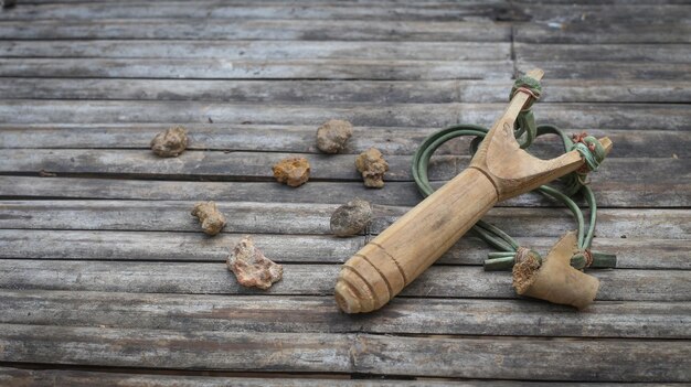 Foto schleuder und steine auf einem holztisch