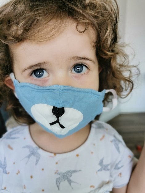 Schließen des kleinen brasilianischen Mädchens mit Maske in Quarantäne.