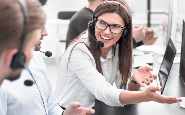 Foto schließen sie das callcenter mit lächelnden mitarbeitern, um geschäftliche probleme zu besprechen