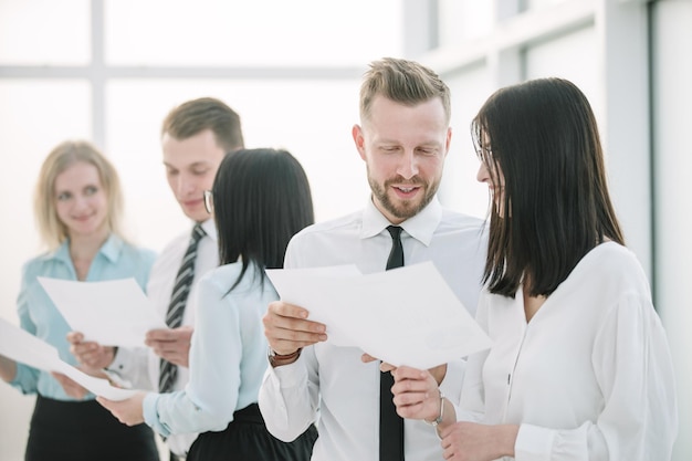 Schließen Sie den Manager und die Mitarbeiter, die Geschäftsdokumente diskutieren