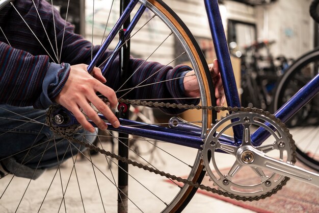 Foto schließen sie die hände, die am fahrrad arbeiten