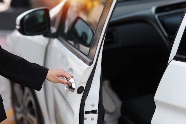 Schließen Sie die weibliche Hand, die eine Auto- oder Autotür öffnet oder schließt