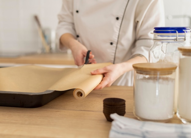 Foto schließen sie hände, die backpapier schneiden