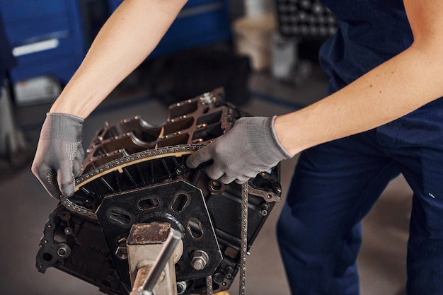 Schließen Sie herauf Ansicht des professionellen Reparaturmanns in der Garage, die mit gebrochenem Automotor arbeitet