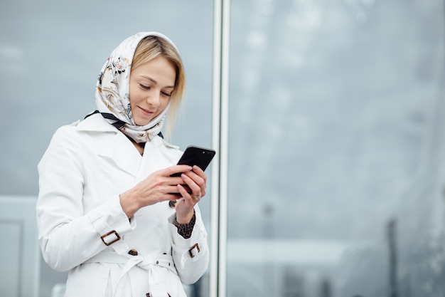 Schließen Sie herauf Ansicht junge Frau in einer großen Stadt mit Telefon