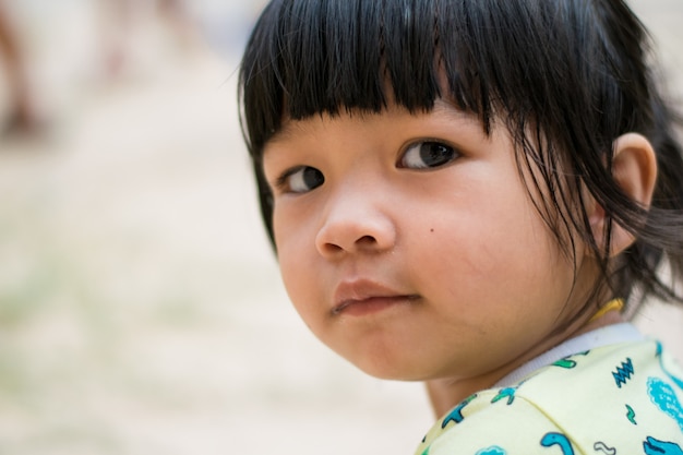 Schließen Sie herauf asiatisches Kindermädchengesicht des Lächelns