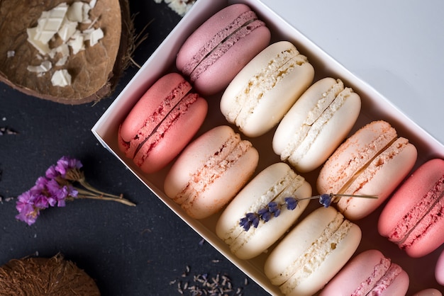 Schließen Sie herauf bunten macarons Nachtisch mit Weinlesepastelltönen auf hölzernem Hintergrund