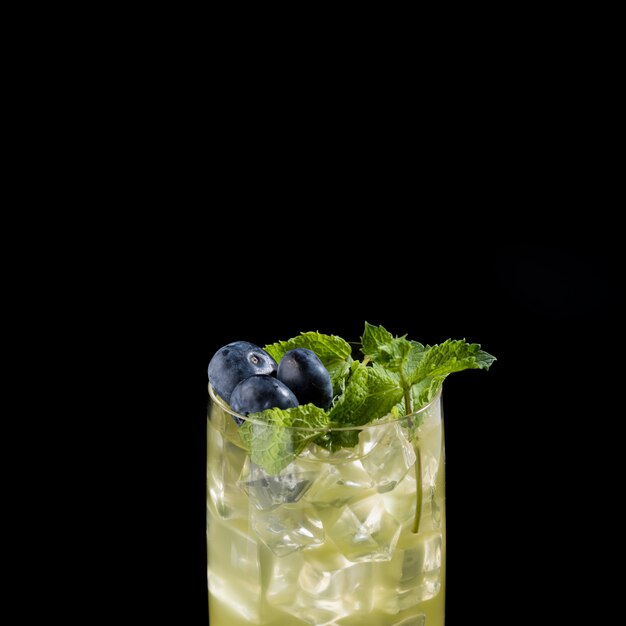 Foto schließen sie herauf cocktail mit eiswürfeln, minze und blaubeeren