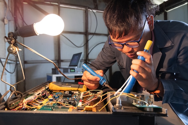 Schließen Sie herauf den Techniker, der Leiterplatte mit Solderer vorbereitet.