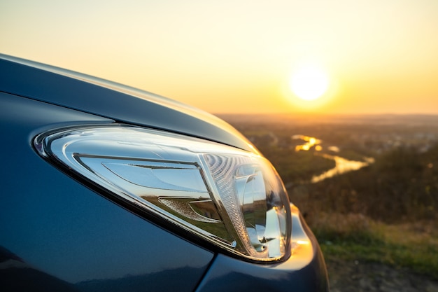 Schließen Sie herauf Detail der vorderen Scheinwerferlampe des modernen Autos bei Sonnenuntergang