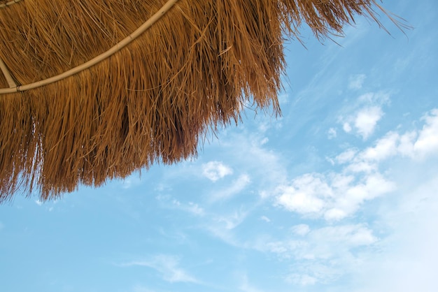 Schließen Sie herauf Detail des gelben Strohdachs gegen blauen Himmel