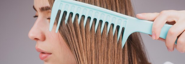 Schließen Sie herauf die Frau, die Haarhaarpflege kämmt schöne Brunettefrau, die Haare mit Haarbürste brus bürstet