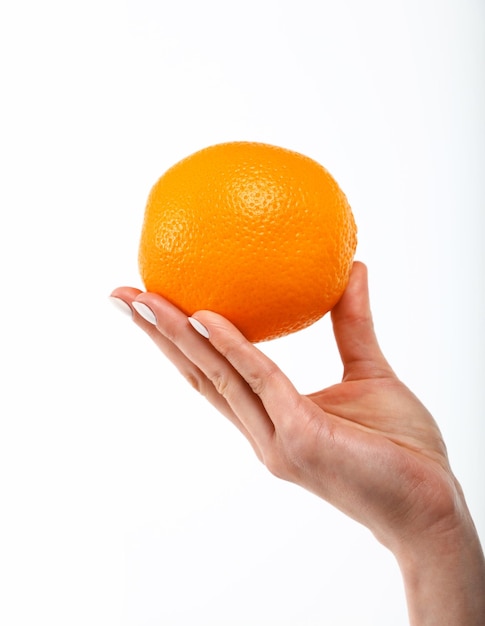 Schließen Sie herauf die Hand der kaukasischen Frau, die eine frische orange Frucht lokalisiert auf weißem Hintergrund, Symbol des Konzepts der gesunden Ernährung, niedriger Winkel, Seitenansicht hält