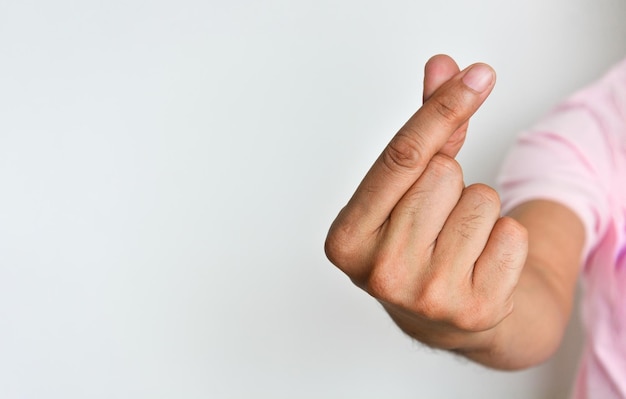 Foto schließen sie herauf die hand des mannes, die miniherzhandzeichen auf weißem hintergrundkopienraum macht