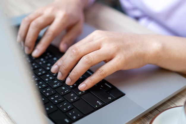 Schließen Sie herauf die Hand einer Geschäftsfrau, die Tastatur-Laptop-Computer auf Schreibtischbüro tippt