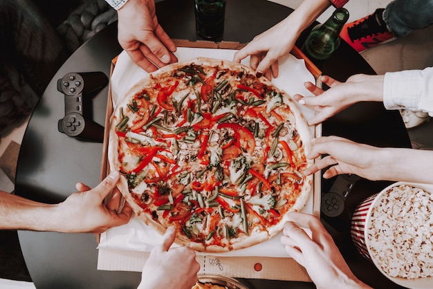 Schließen Sie herauf die junge Firma, die Pizza auf Partei isst