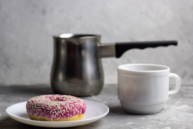 Schließen Sie herauf Donut auf einem Teller unscharfen Kaffeetassenhintergrund