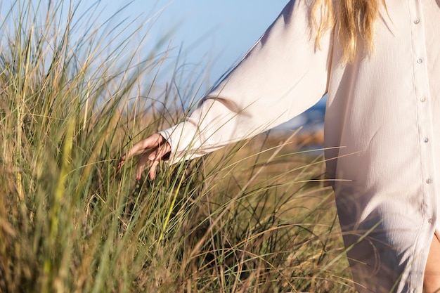 Foto schließen sie herauf frau, die gras berührt