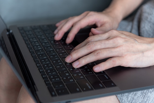 Foto schließen sie herauf frauenhand, die auf laptop arbeitet oder tippt