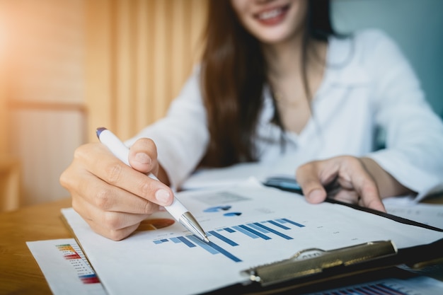 Schließen Sie herauf Geschäftsfrauhandbehälter und Zeigen auf Finanzschreibarbeit.