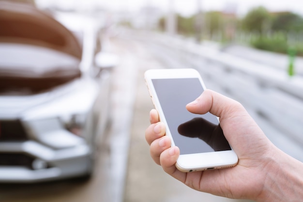 Schließen Sie herauf Geschäftsmannhand, die ein mobiles Smartphone anruft, rufen Sie einen Automechaniker an, der um Hilfe bittet, weil das Auto am Straßenrand kaputt ist.