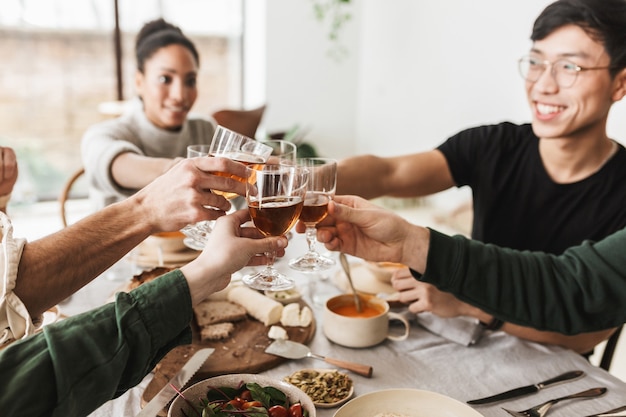 Schließen Sie herauf Gruppe der internationalen Freunde, die Gläser Wein in den Händen halten