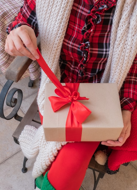 Schließen Sie herauf Hände, die Weihnachtsgeschenk öffnen