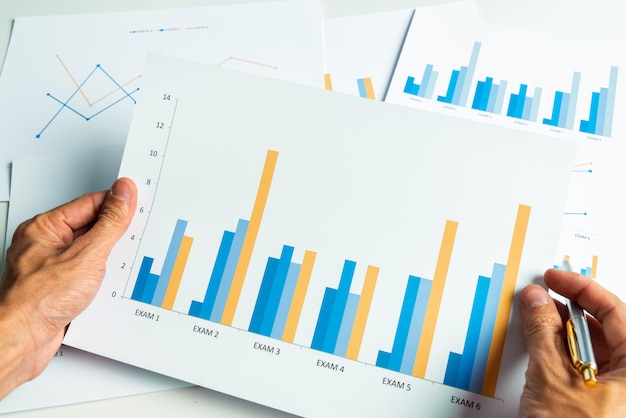 Schließen Sie herauf Hand des Geschäftsmannes mit Bilanzanalyse des Finanzberichts.