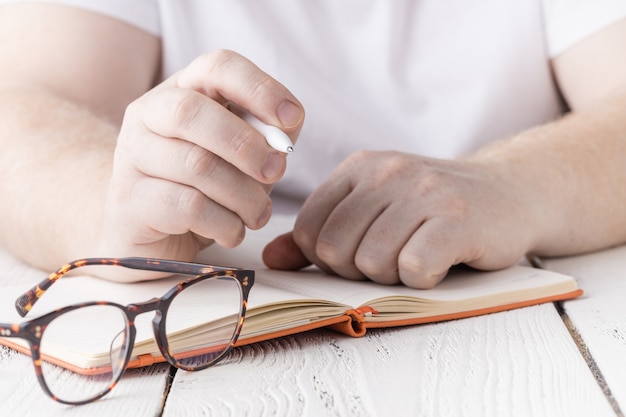 Schließen Sie herauf Hand des Schülers, der Notizen in Notizbuch schreibt