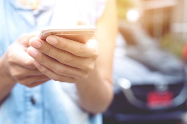 Schließen Sie herauf Handleute Frau stehen unter Verwendung des mobilen Smartphones am Straßenrand