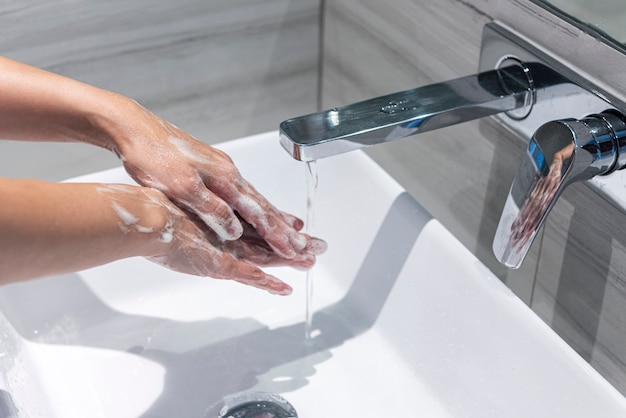 Schließen Sie herauf Handwaschhände im Waschbecken, Reinigungshandkonzept