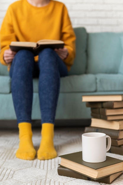 Schließen Sie herauf Leser mit Buch auf Couch